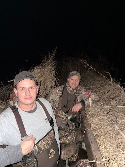 Two hunters settle into a blind before dawn